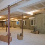 Basement remodeling project by SC Projects LLC showing exposed support columns, new drywall ceiling, and egress windows prior to finishing .