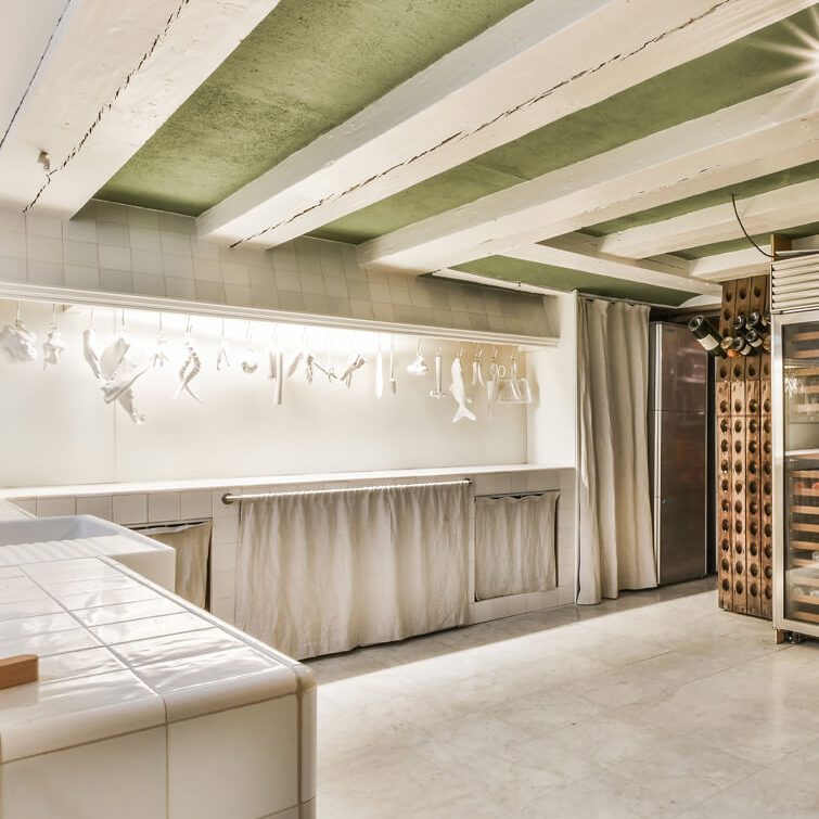 An interior image of a large, tiled, rustic-style prep or storage area with exposed white ceiling beams and a green ceiling installed by SC Projects LLC.